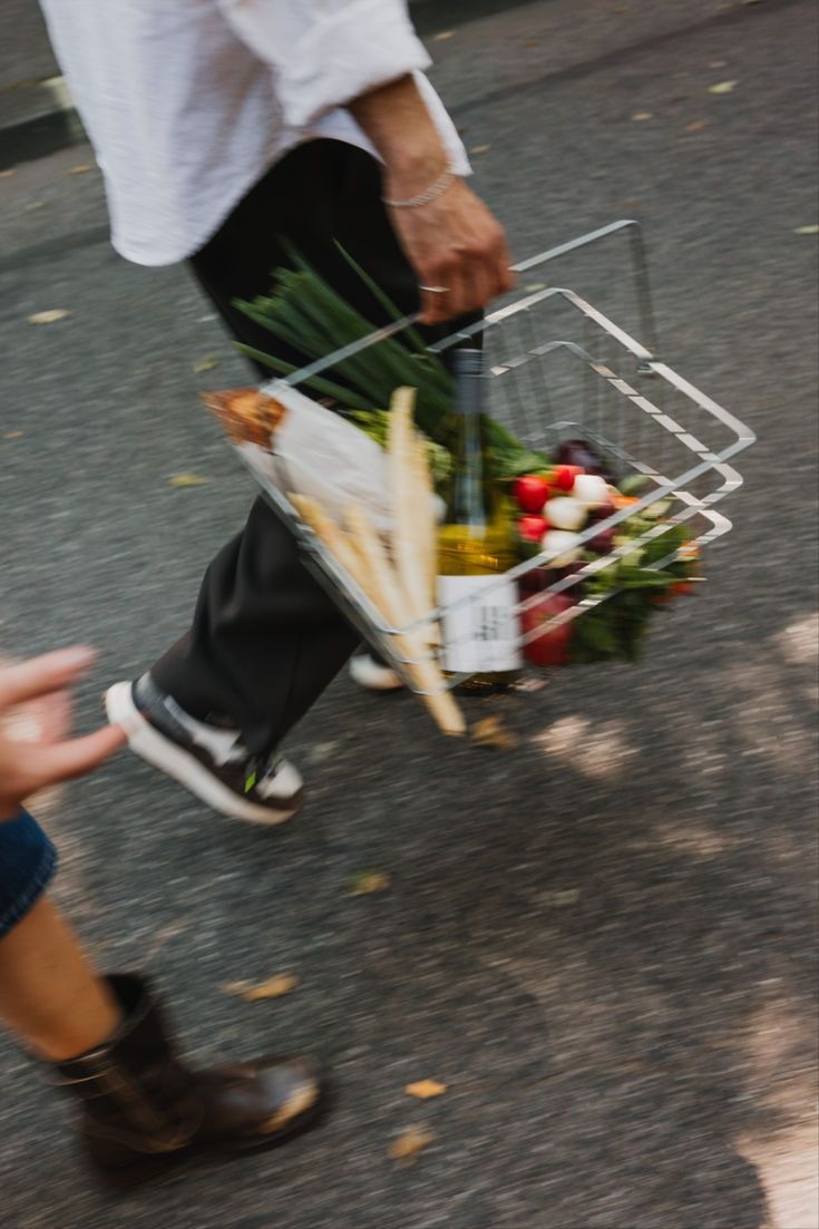 Person carrying a basket of fresh produce